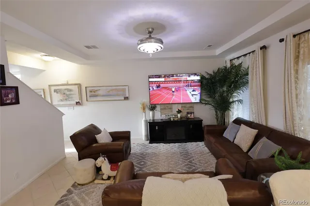 a living room with furniture a chandelier and a flat screen tv