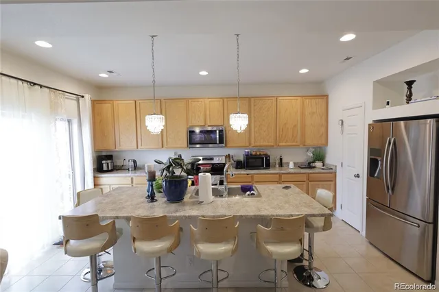 a kitchen with a table chairs refrigerator and microwave