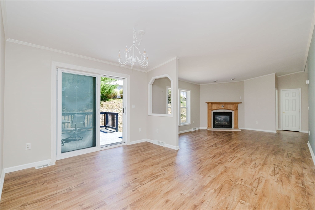 2602 Green Street Middleboro, MA 02346 - Photo 8 of 26 an empty room with wooden floor fireplace and windows