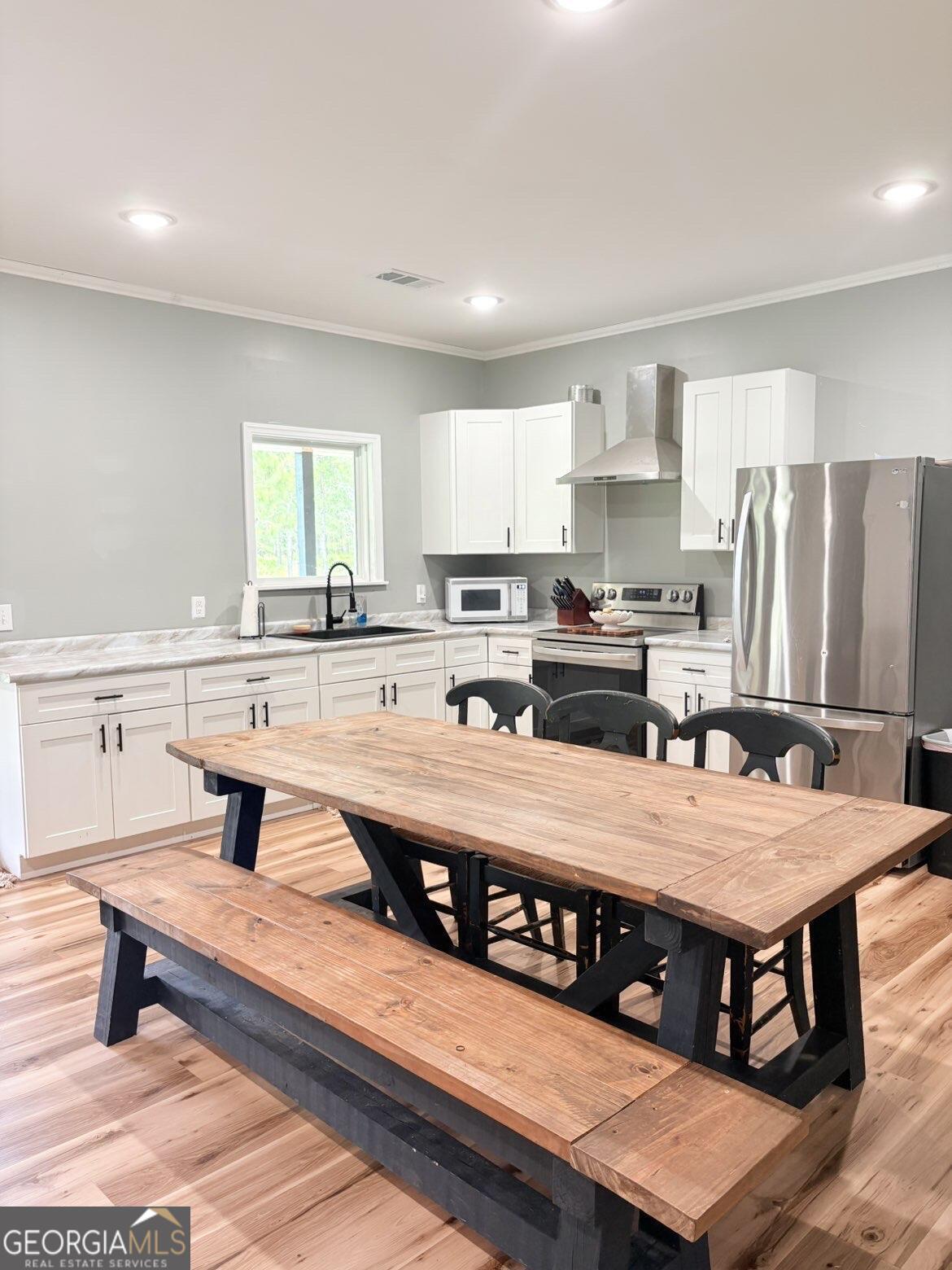 210 St Galilee Road Swainsboro, GA 30401 - Photo 6 of 18 a kitchen with stainless steel appliances a table and chairs in it