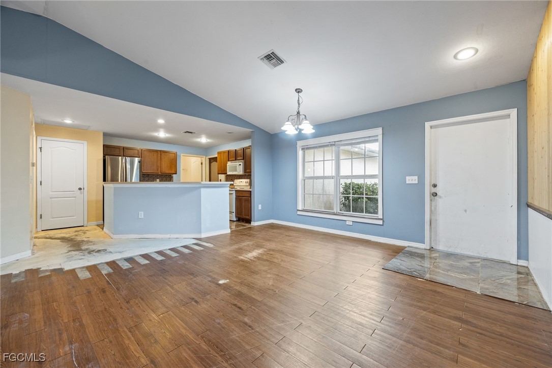 2406 East 23rd Street Alva, FL 33920 - Photo 11 of 33 a view of an empty room with wooden floor and a kitchen