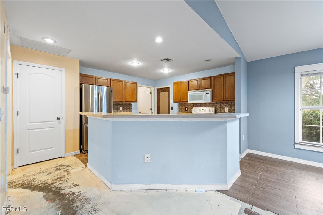 2406 East 23rd Street Alva, FL 33920 - Photo 12 of 33 a living room with stainless steel appliances kitchen island granite countertop a refrigerator and a sink