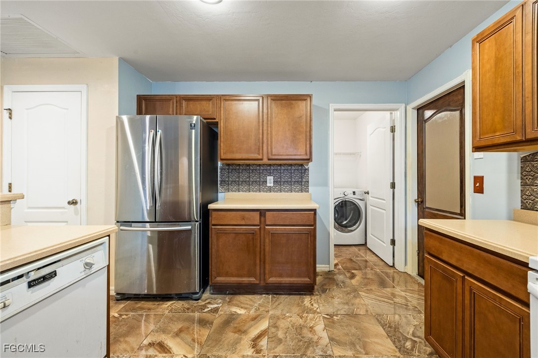 2406 East 23rd Street Alva, FL 33920 - Photo 15 of 33 a kitchen with a refrigerator sink and cabinets