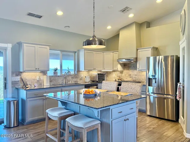a bedroom with a large bed a chandelier and dresser