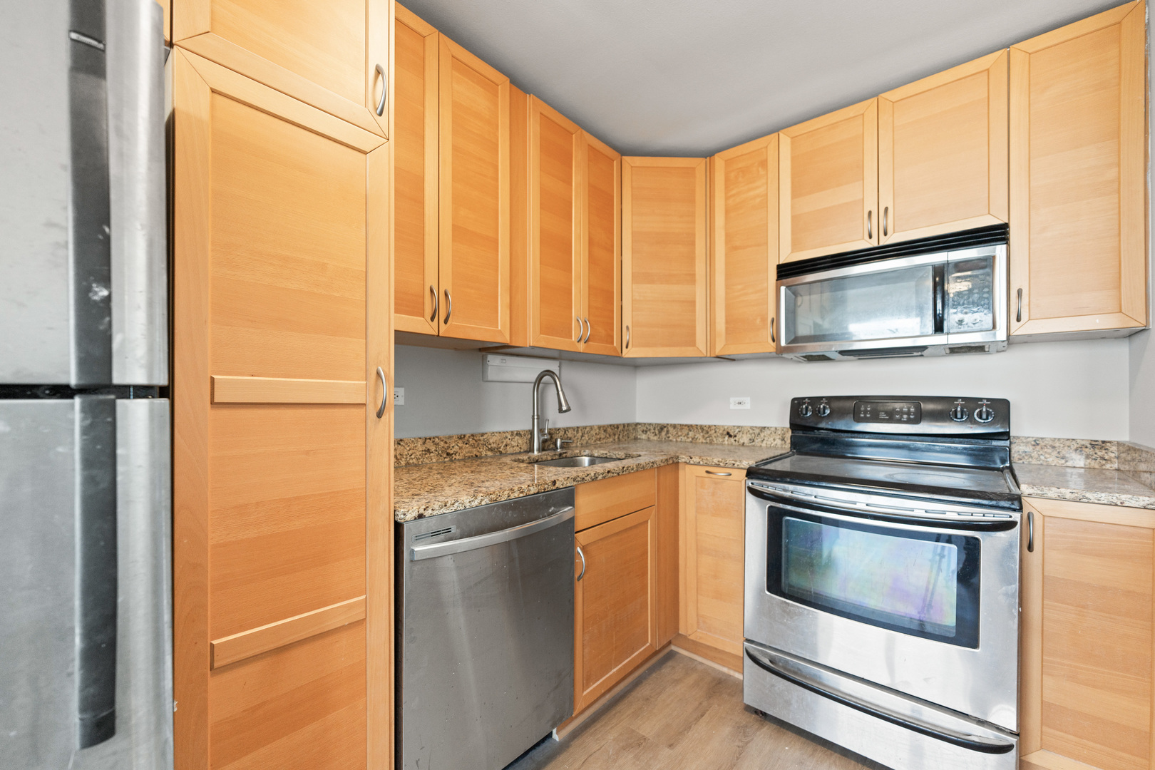 655 West Irving Park Road, Unit 5306 Chicago, IL 60613 - Photo 13 of 28 a kitchen with granite countertop cabinets stainless steel appliances and a counter space