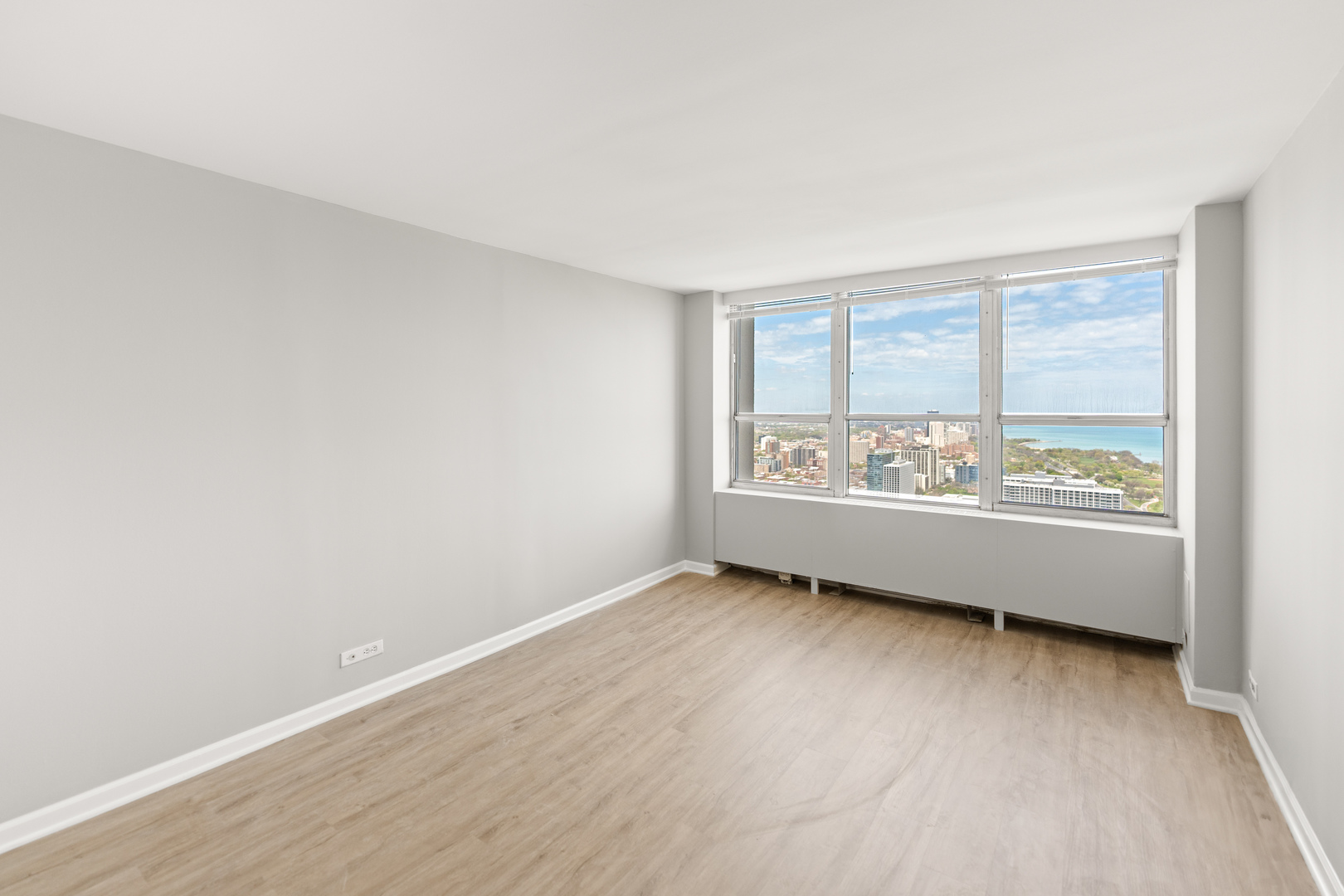 655 West Irving Park Road, Unit 5306 Chicago, IL 60613 - Photo 17 of 28 an empty room with wooden floor and windows