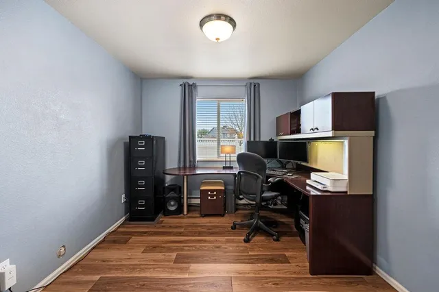 a view of a workspace with furniture and a window