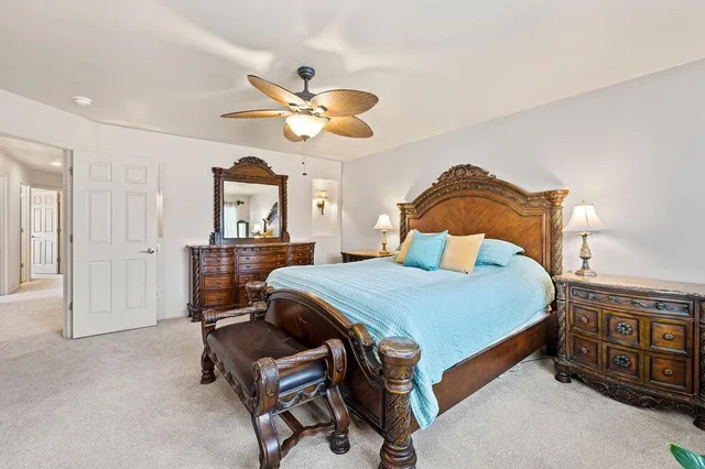 a bedroom with a bed a chandelier and dresser