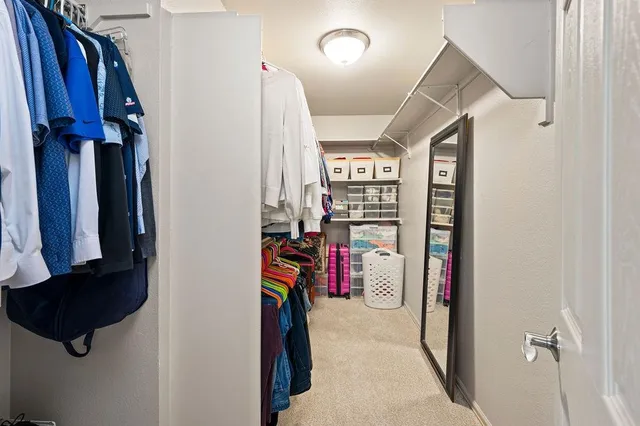 a view of walk in closet with clothes and shoes