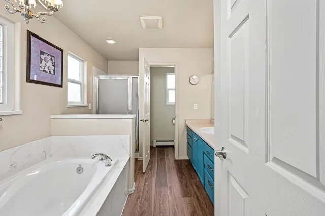 a bathroom with a tub sink and mirror