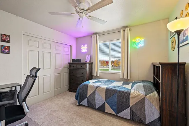 a bedroom with a bed a desk and chair with a bookshelf