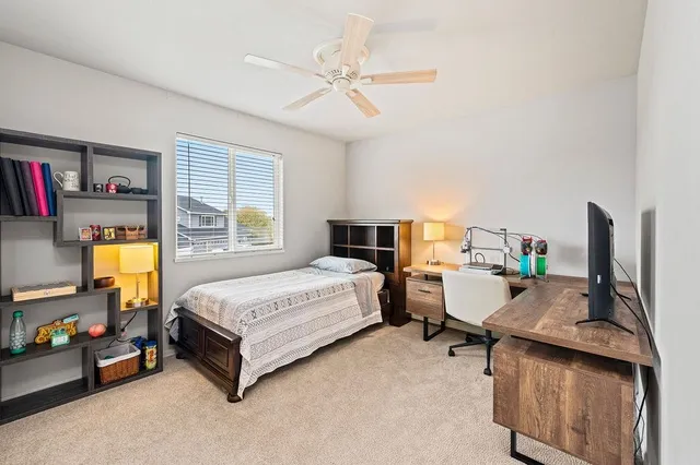 a bedroom with a bed workspace and window