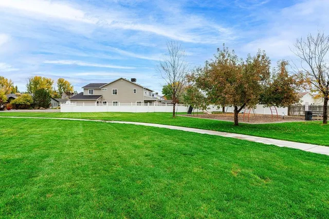 a view of a house with a big yard and large trees