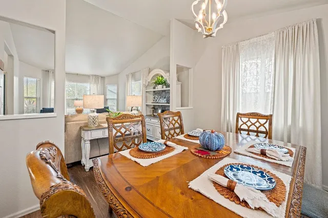 a view of a dining room with furniture a chandelier and wooden floor