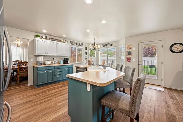 a kitchen with stainless steel appliances kitchen island granite countertop a kitchen island hardwood floor and a sink