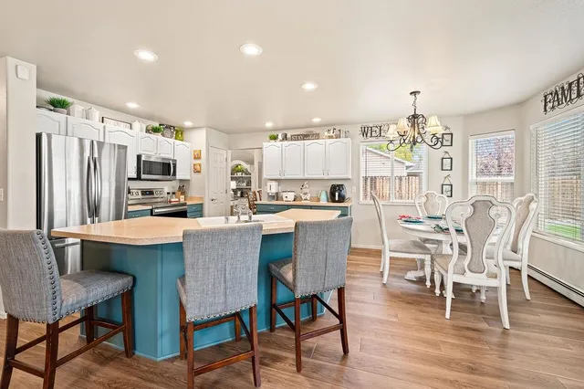 a dining room with stainless steel appliances a table and chairs