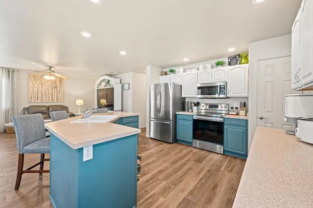a kitchen with stainless steel appliances kitchen island a refrigerator sink and stove