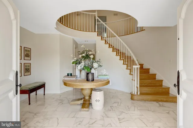 a dining room with wooden floor a chandelier a wooden table and chairs