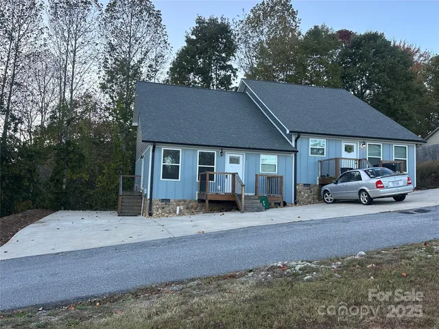 a front view of a house with a yard and car parked