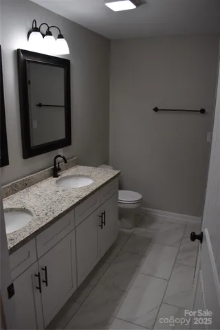 a bathroom with a granite countertop sink and toilet
