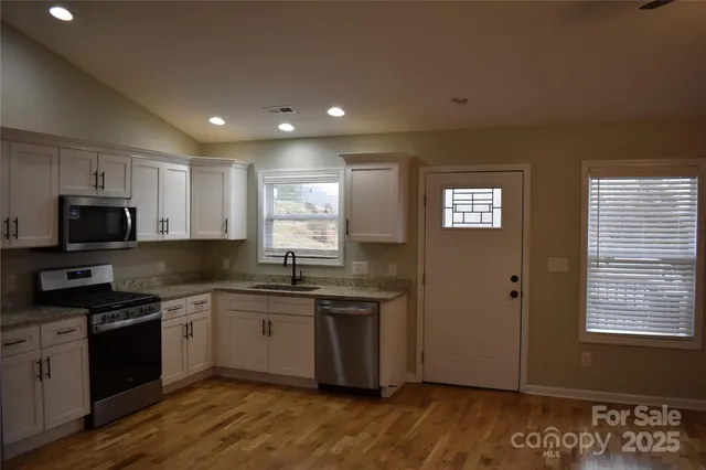 a bathroom with a granite countertop toilet sink and mirror