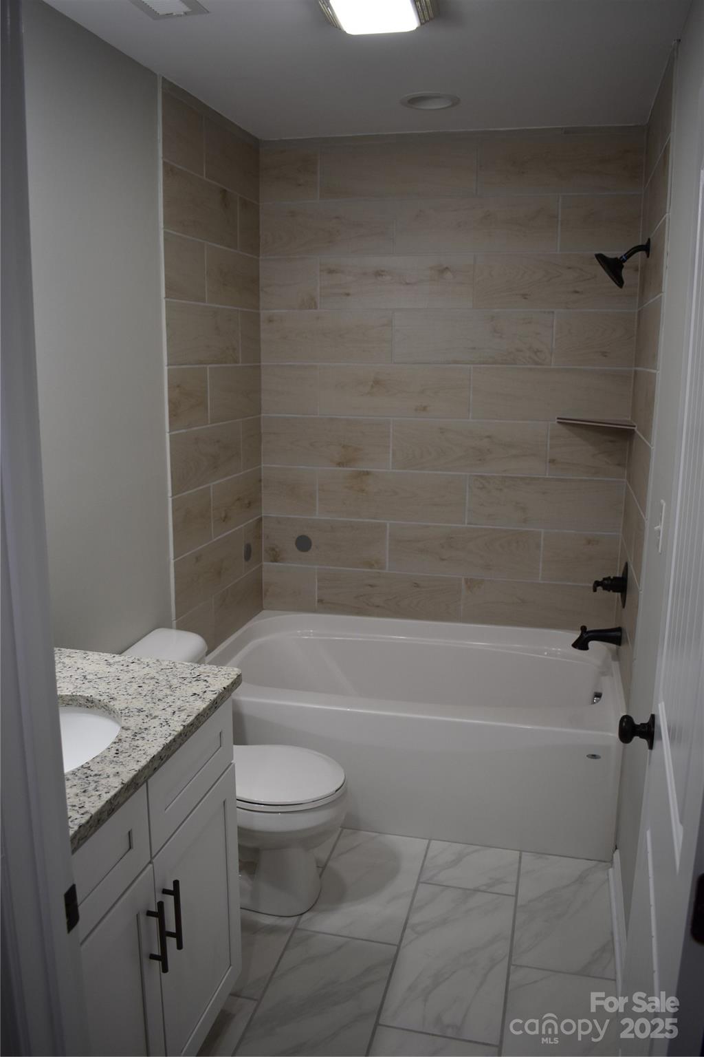 17 Meredith Lane Marion, NC 28752 - Photo 39 of 42 a bathroom with a granite countertop bathtub shower sink vanity and toilet