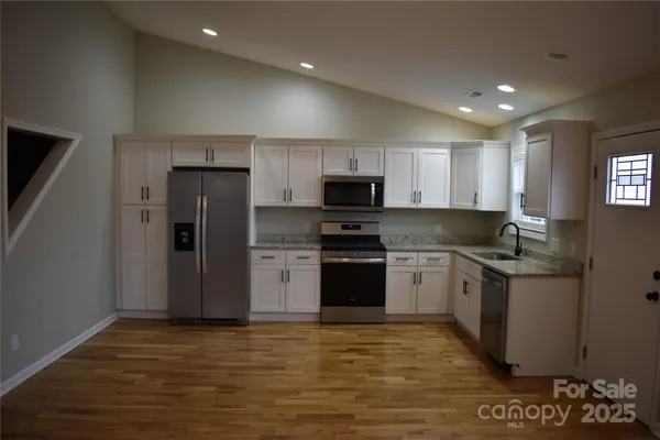 a kitchen with a sink a refrigerator and a stove top oven