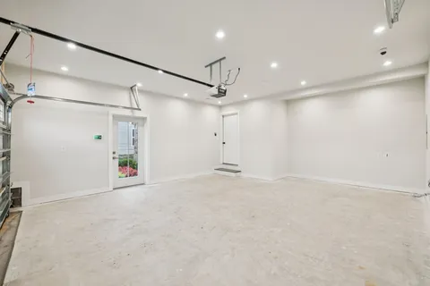 an empty room with ceiling fan and windows