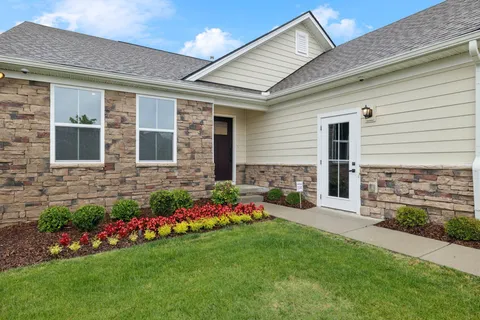 a front view of a house with a yard and outdoor seating