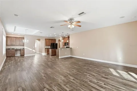 a view of a kitchen with wooden floor and a kitchen space with a sink