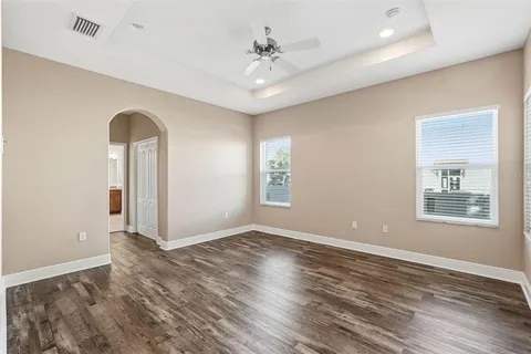 a view of an empty room with window and wooden floor