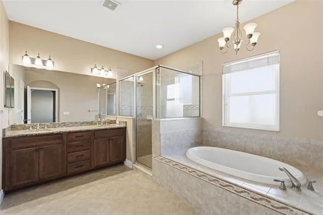 a bathroom with a granite countertop sink a toilet a mirror and shower
