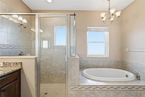 a bathroom with a tub a sink and mirror