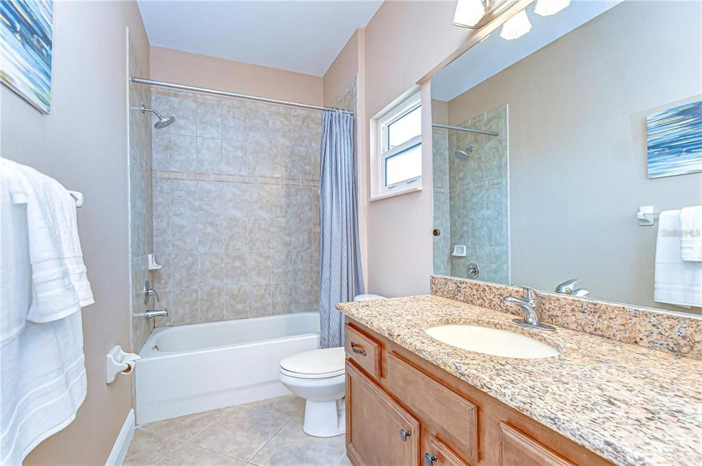 2506 West Ivy Street Tampa, FL 33607 - Photo 28 of 40 a bathroom with a granite countertop sink toilet and shower