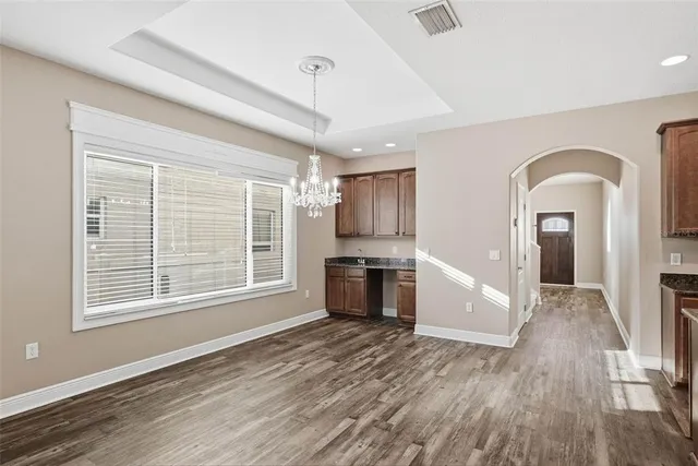 a view of empty room with kitchen and window