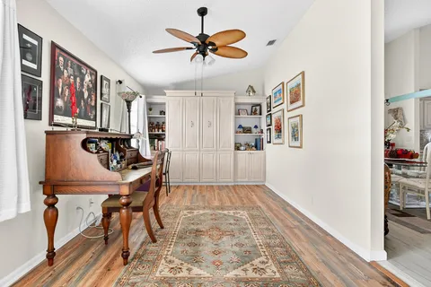 a view of a workspace with furniture and a ceiling fan