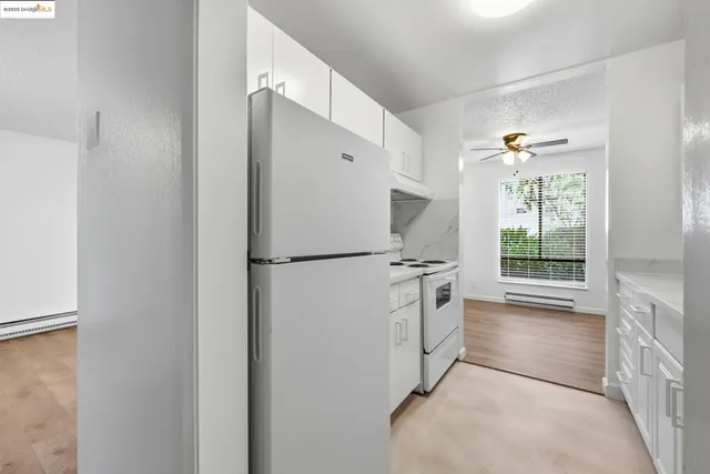 a kitchen with white cabinets and white appliances