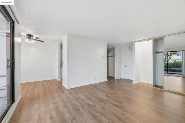 a view of an empty room with wooden floor