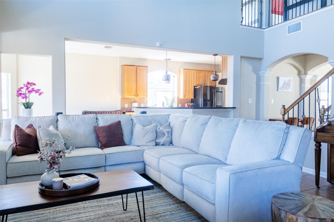 3113 Quail Run Round Rock, TX 78681 - Photo 12 of 29 Living room featuring a towering ceiling, and ornate columns. Open to the kitchen