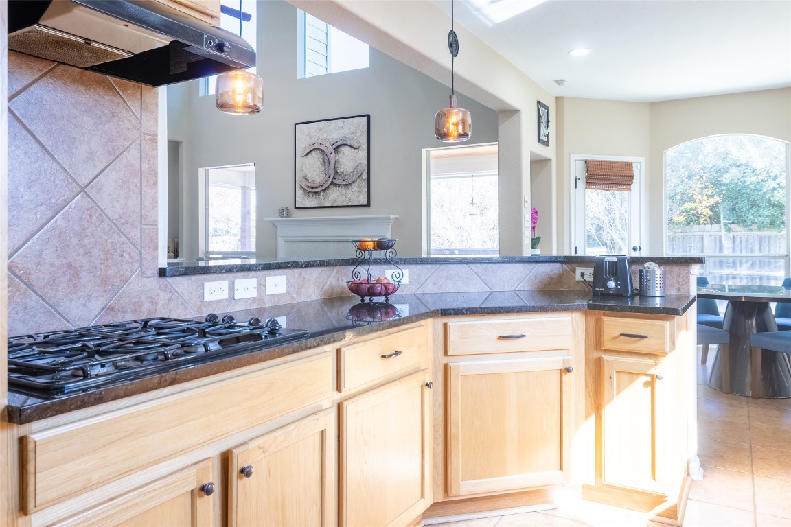 3113 Quail Run Round Rock, TX 78681 - Photo 13 of 29 Kitchen featuring light brown cabinetry, under cabinet range hood, black gas cooktop, and plenty of natural light