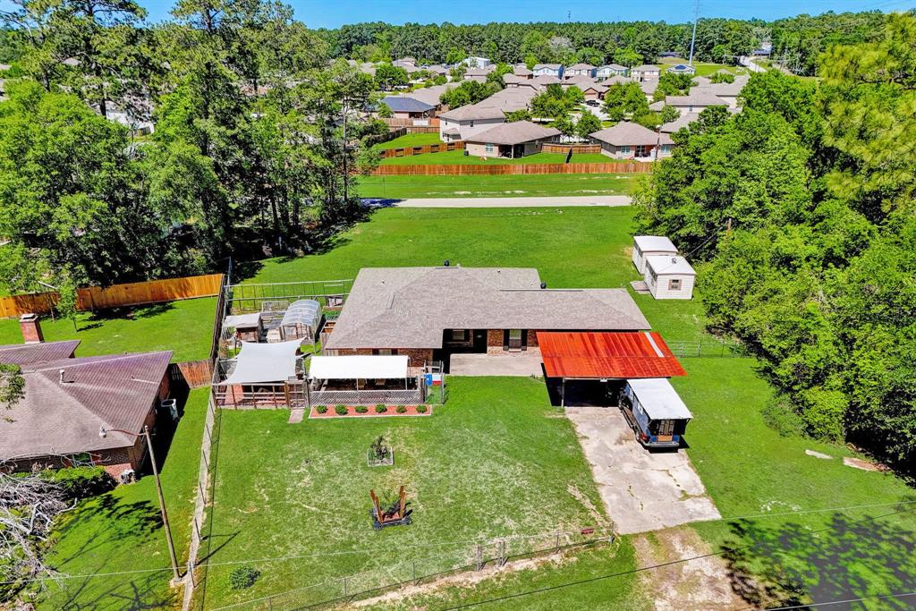 an aerial view of a house with swimming pool big yard and large trees