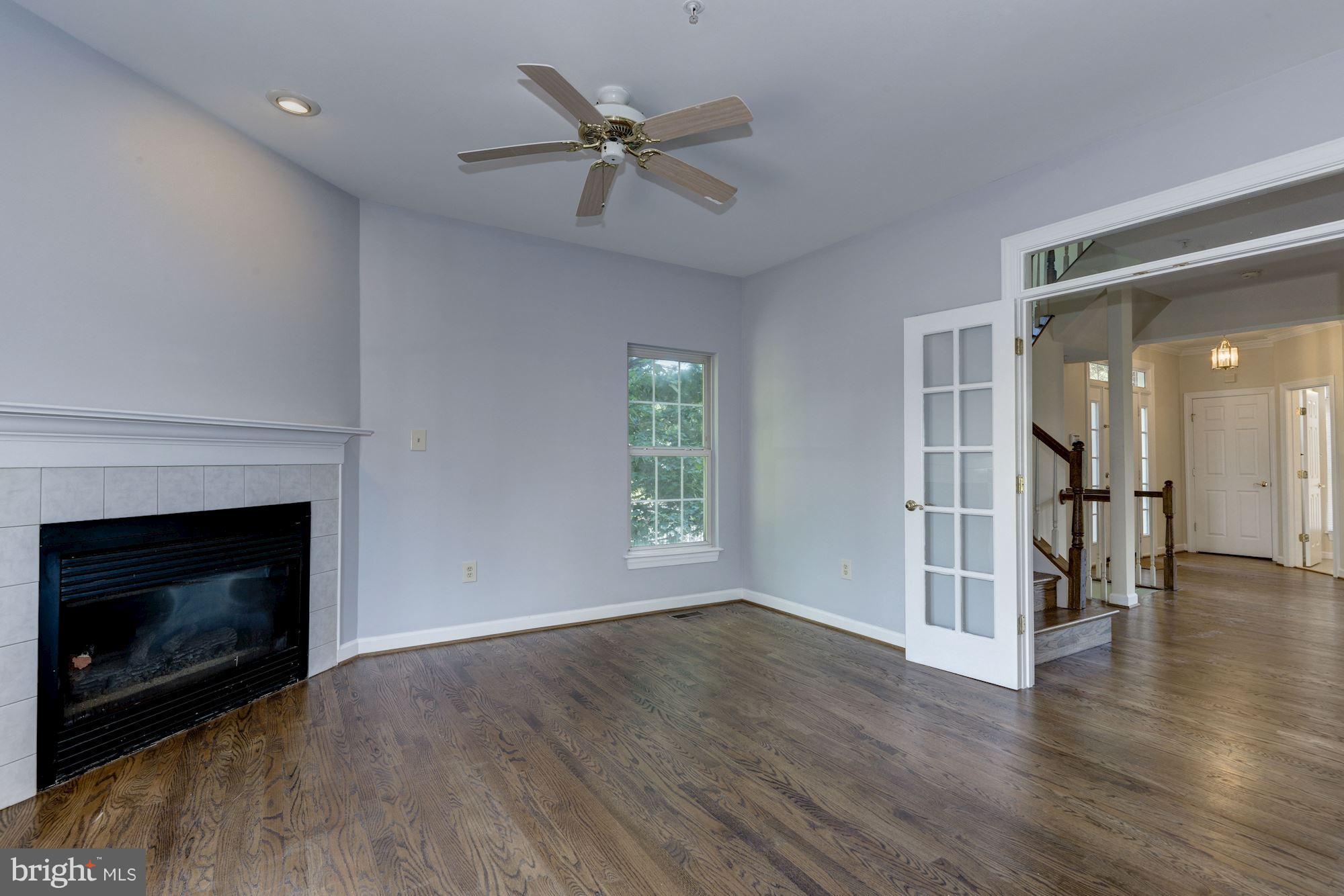 2101 Hounds Run Place Silver Spring, MD 20906 - Photo 8 of 30 a view of an empty room with wooden floor fireplace and a window