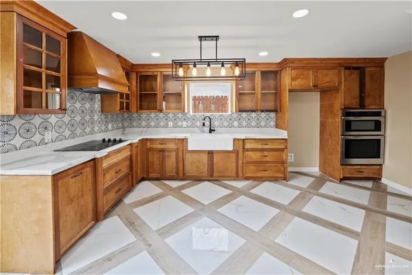 a large kitchen with stainless steel appliances granite countertop a sink and cabinets
