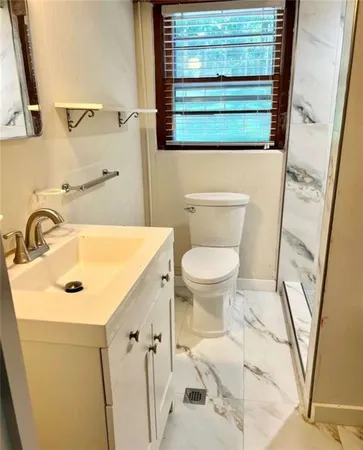 a view of an empty room with window and chandelier fan