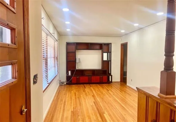 a view of a hallway with wooden floor and staircase