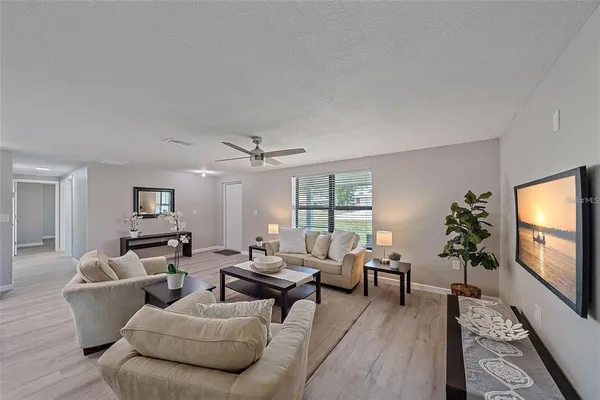 a living room with furniture flat screen tv and window