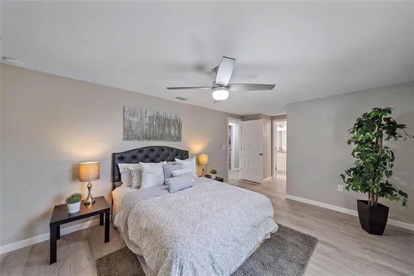 a bedroom with a bed and a potted plant