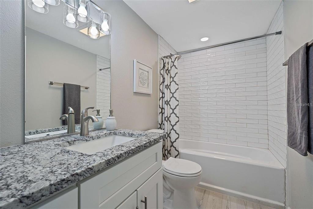 105 Clemson Road Venice, FL 34293 - Photo 14 of 15 a bathroom with a granite countertop sink a toilet and shower
