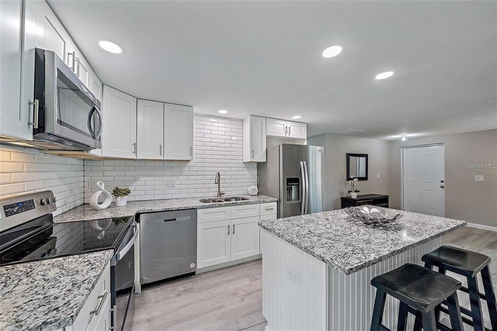 105 Clemson Road Venice, FL 34293 - Photo 2 of 15 a kitchen with a stove a sink a refrigerator and cabinets
