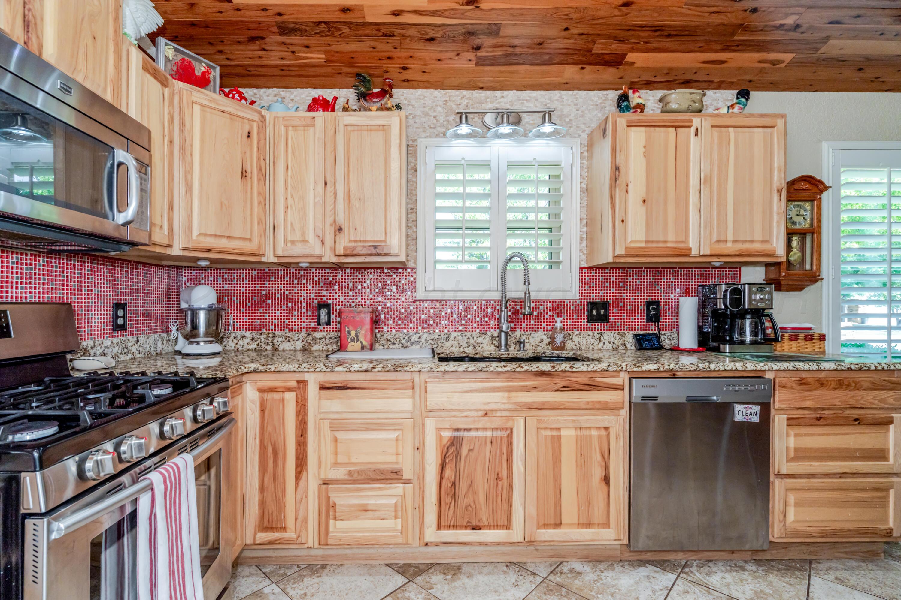 3908 Lewis Drive Amarillo, TX 79109 - Photo 6 of 36 a kitchen with stainless steel appliances granite countertop a stove a sink and a microwave